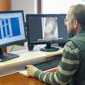 Ein Mann arbeitet am Computer mit CAD-Software für Fensterdesign und Architekturplanung.