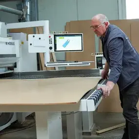 Ein Mitarbeiter bedient eine CNC-Holzbearbeitungsmaschine in einer modernen Schreinerei.