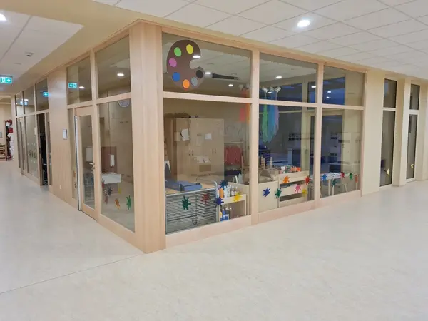 Kreativraum im Kindergarten mit Bastelmaterial, bunter Farbpalette und Fensterdekoration.